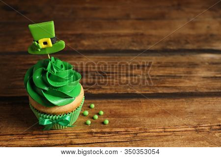 Delicious Decorated Cupcake On Wooden Table, Space For Text. St. Patrick's Day Celebration