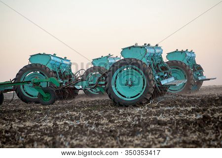 Agricultural Mechanical Seeders Of Grain Crops. Tactor With A Seeder Sows Grain In The Field. A Farm