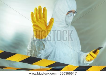 Epidemiologist Using Smartphone In Hospital Virus Infection Quarantine And Gesturing Stop Hand Sign,