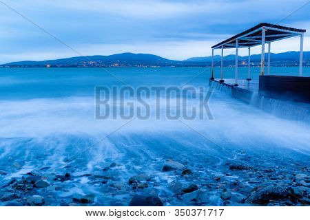 Storm Waves At High Speed Run Over The Stones Of Gelendzhik Beach. Waves Due To Exposure Are A Blue 