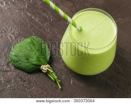 A Bunch Of Spinach Leaves And A Glass Glass With A Smoothie On A Stone Background. Fitness Product. 