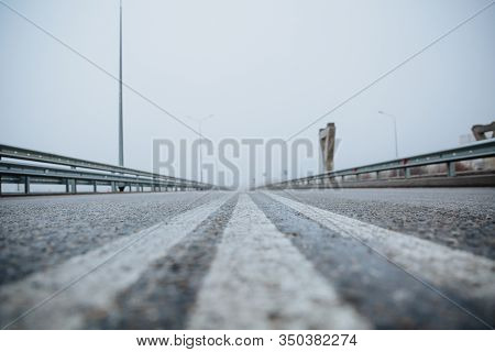 The Dividing Line On The Road Is White The View From Below On The Road Paved Going. Road Markings On