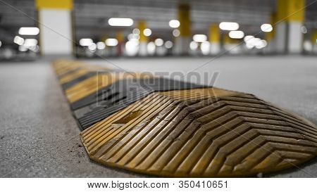 Traffic Safety Speed Bump On An Asphalt Road In A Parking Area. Speed Bumps (or Speed Breakers) Are