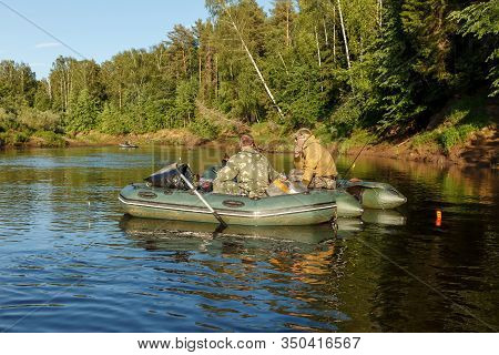 Tuzha, Russia - June 15, 2019: Fishermen Catch Fish On A Rubber Boat On A Forest River. Pizhma River