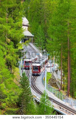 Zermatt, Switzerland - October 7, 2019: Two Gornergrat Red Tourist Trains On The Bridge In Swiss Alp