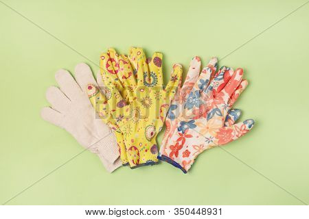 Three Pair Of Gardening Gloves On Green Background Gardening Concept Flat Lay Top View