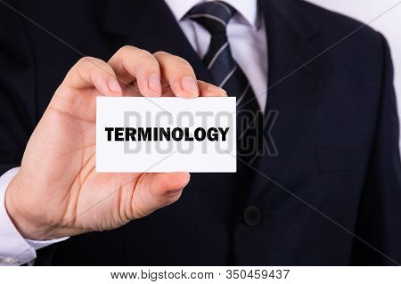 Businessman Holding A Card With Text Terminology