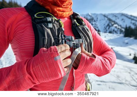 Young Woman Fastens Running Backpack Before Jogging In Winter Mountains Trail On Snow