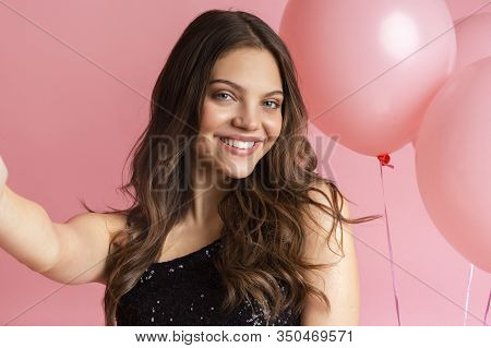 Girl Party. Selfie Portrait Of Young Pretty Woman Smiling At Camera With Big Pink Balloons On Backgr