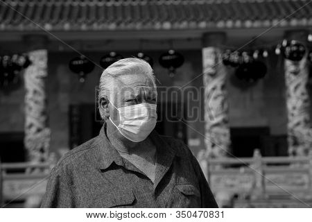  2019 Novel Coronavirus. 2019-nCoV. Wuhan China Coronavirus. A man wears a paper face mask to protect himself from contracting the Wuhan 2019 Novel Coronavirus. The 2019-nCoV is spreading world wide. 