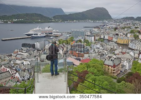 Man Photographing City Of Alesund In Norway From Look Out Point Of Fjellstua