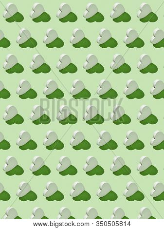 Decorative feative pattern from plaster vertical standing hearts on a light green background with hard shadows. Valentine's greeting card.