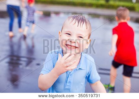 A Happy Toddler Is Refreshing In A Fountain