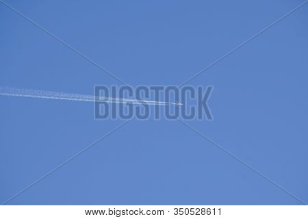 Clear Blue Sky With Random Traces Of Burned Fuel From The Plane On A Clear Sunny Day.