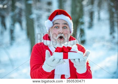 Santa Claus Comes With Gifts From The Outside. Santa In Red Suit Walking Along The Road To Christmas