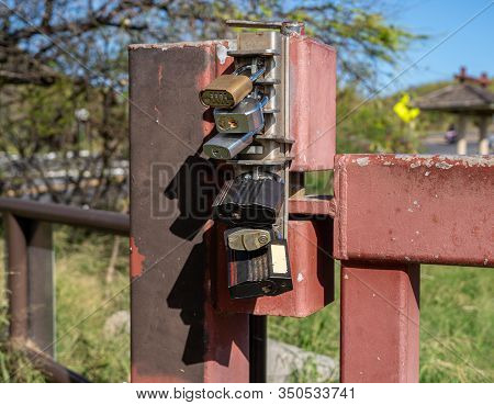 Overkill With Six Different Padlock Locks Securing A Metal Gate From Being Opened