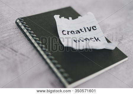 Scrunched Paper With Creative Block Text On Desk With Notepad, Lack Of Inspiration