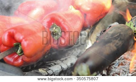 Red Peppers And Eggplant Are Grilled. Close-up. Macro. Coals.