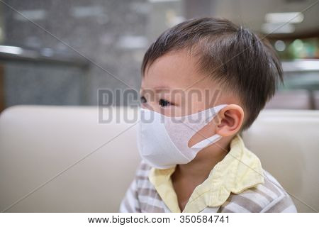 Cute Little Asian 2 - 3 Years Old Toddler Boy Child Wearing Protective Medical Mask, Kid Sitting On 