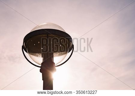 Upper Part Of A Street Lamp In Sunset With Taillight