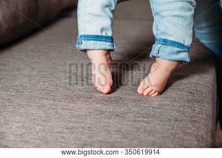 Baby's First Steps. The Baby's Feet Take The First Steps. Photo Of Children's Legs Barefoot.