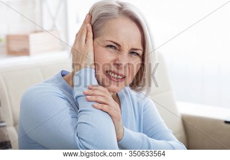 Tinnitus. Closeup Up Side Profile Sick Female Having Ear Pain Touching Her Painful Head. Concept Pho