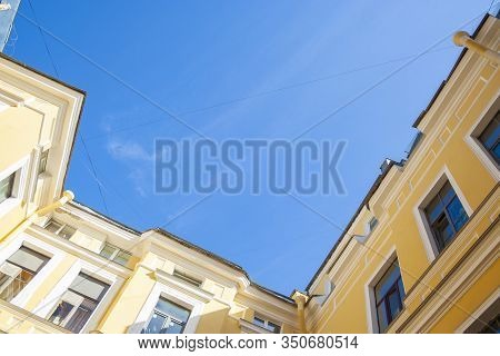 Saint-petersburg In Russia Courtyard With Orange Rough Walls Shot From Bottom To The Blue Sky. House