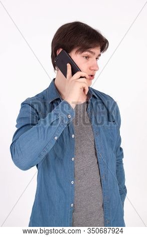 Young Smiling Man Talking On The Mobile Phone And Looking Away. Isolated On White.