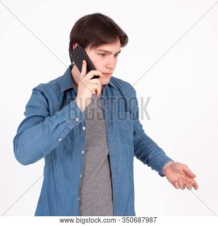 Young Smiling Man Talking On The Mobile Phone And Looking Away. Isolated On White.