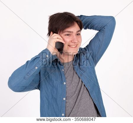 Young Smiling Man Talking On The Mobile Phone And Looking Away. Isolated On White.