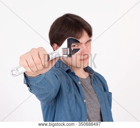 Portrait Of Young Man While Holding Wrench On White Background.