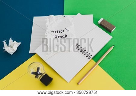 Piece Of Paper With Writer's Block Text On Top Of Blank Notepads With Pencil Eraser Scrunched Paper 