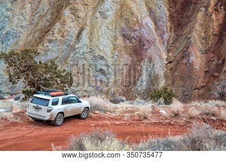 Moab , UT, USA - February 9, 2020:  Toyota 4runner SUV (2016 trail edition, stock vehicle) with recovery ladders on roof racks on a desert canyon road - Onion Creek Trail, recreation concept.