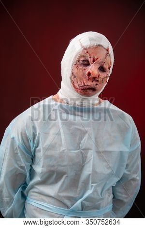 Crazy Zombie Horror Make Up. Person In Blue Madical Shirt And Bandaged Head. Scars, Deep Scratches R