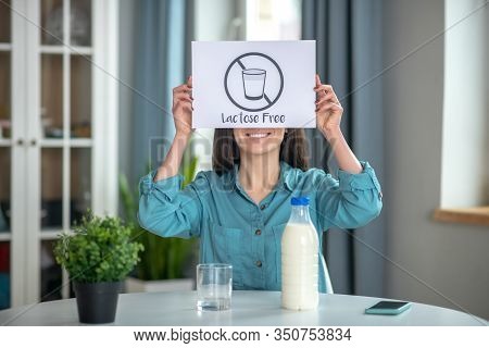 Woman Holding A Lactose Free Sign While Drinking Milk