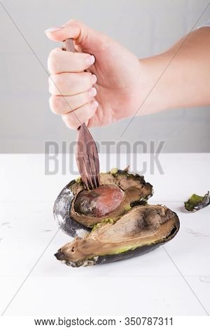 Woman Puts Rotten Avocado On A Fork. Concept Of Stop Wasting Food, Don't Waste Food In Supermarket A