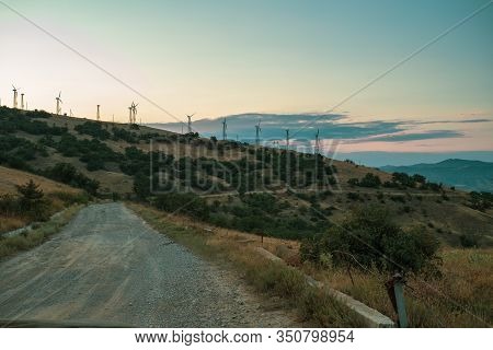 Way Old Road In Wind Farm At Cape Meganom Early Morning Or Evening In Summer In Crimea, Russia.