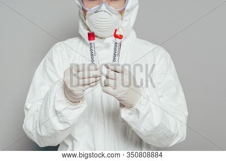 Cropped View Of Epidemiologist In Hazmat Suit And Respirator Mask Holding Test Tubes With Blood Samp