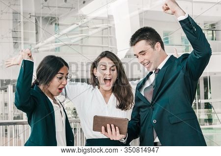 Three Good Looking Colleagues Standing In Office Corridor, Exulting, Receiving Good News, Raising Up