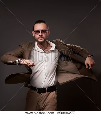 Man with beard jacket in movement on empty brown background