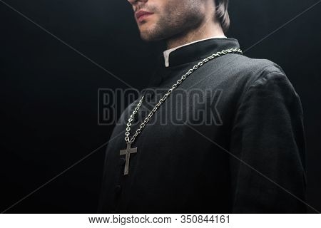 Cropped View Of Catholic Priest In Black Cassock With Silver Cross On Necklace Isolated On Black