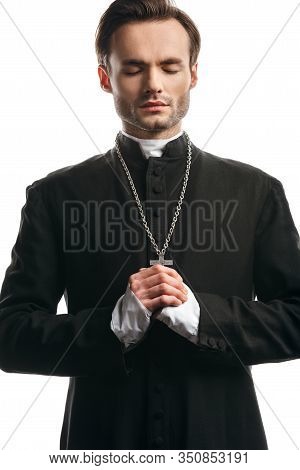 Concentrated Catholic Priest Praying With Closed Eyes Isolated On White