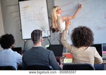 young business female rising hand at the meeting asking permission to speak or ask a question. conference, meeting, business, presentation 