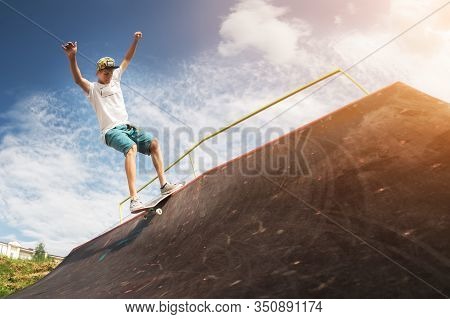 Portrait Of A Young Skateboarder Doing A Trick On His Skateboard On A Halfpipe Ramp In A Skate Park 