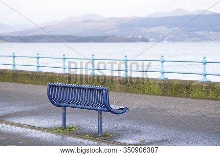 Lonely Empty Bench In Open Esplanade Tranquil Space On Scottish West Coast Town In Greenock