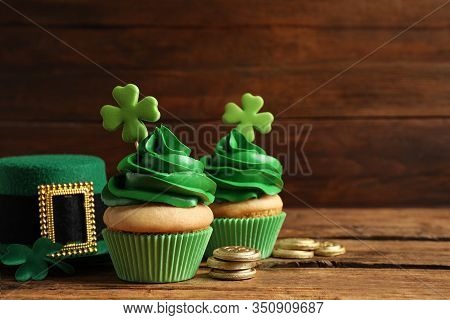 Composition With Delicious Decorated Cupcakes On Wooden Table, Space For Text. St. Patrick's Day Cel