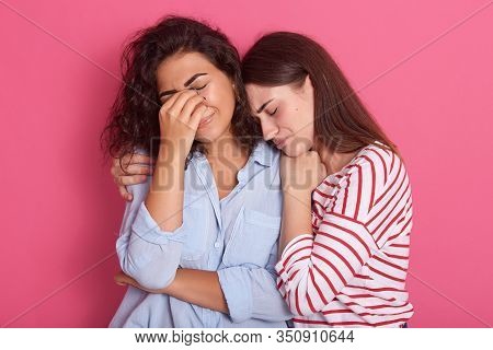 Close Up Portrait Of One Woman Crying And Another Embracing Her And Calming Down, Female Wearing Blu