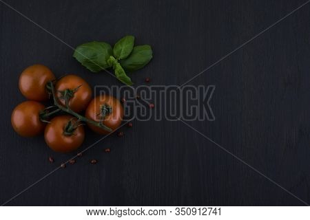 Fresh Grape Tomatoes With Pepper For Use As Cooking Ingredients On Black Wooden Background