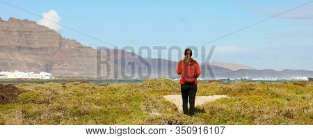 Hiking In Spring Time. Back View Of Girl Exploring The Northern Of The Island Of Lanzarote, Canary I