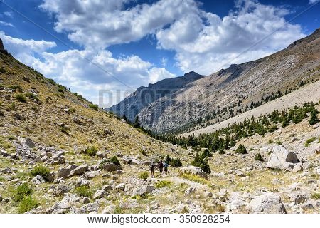 Turkey, Chamard - August 3, 2019: Tourists Walk Along The Road Through The Mountain Landscape In The